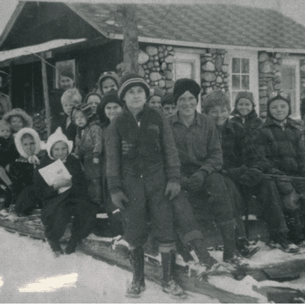 Children gathered on a sled outside the church in the early years