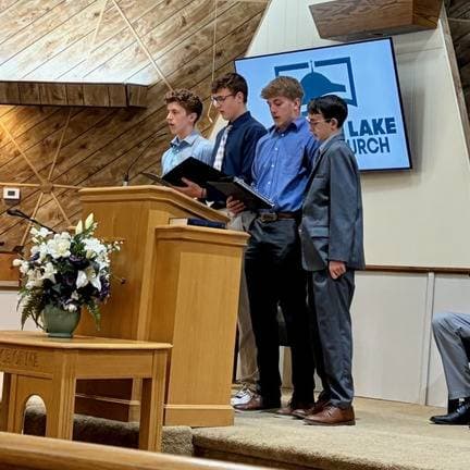 Young men singing at the pulpit beneath the dome